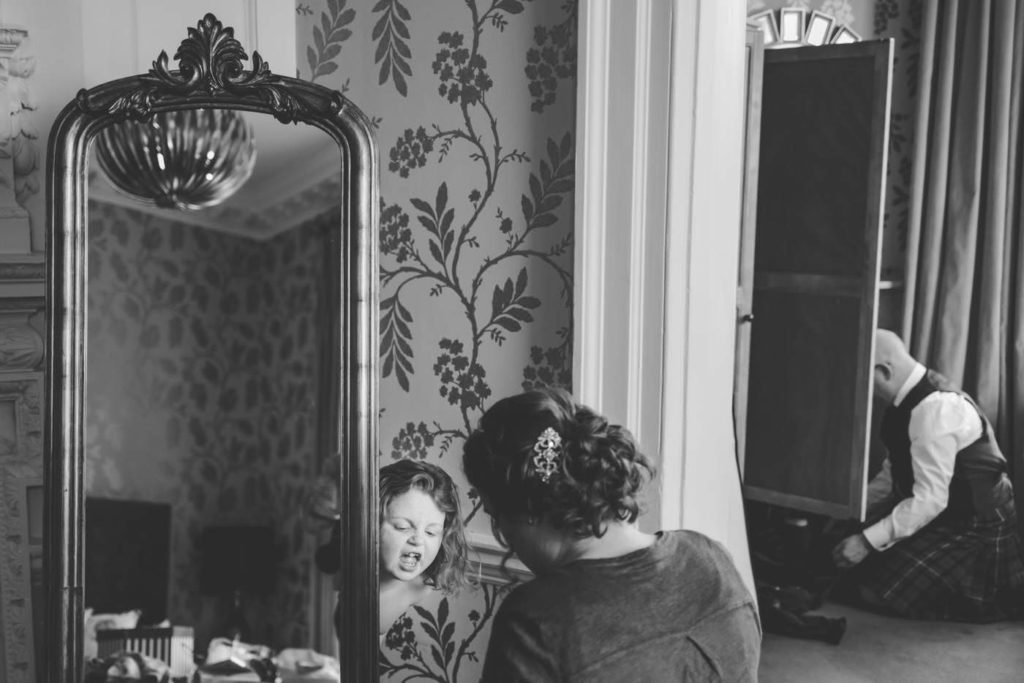 flower girl hides behind the mirror